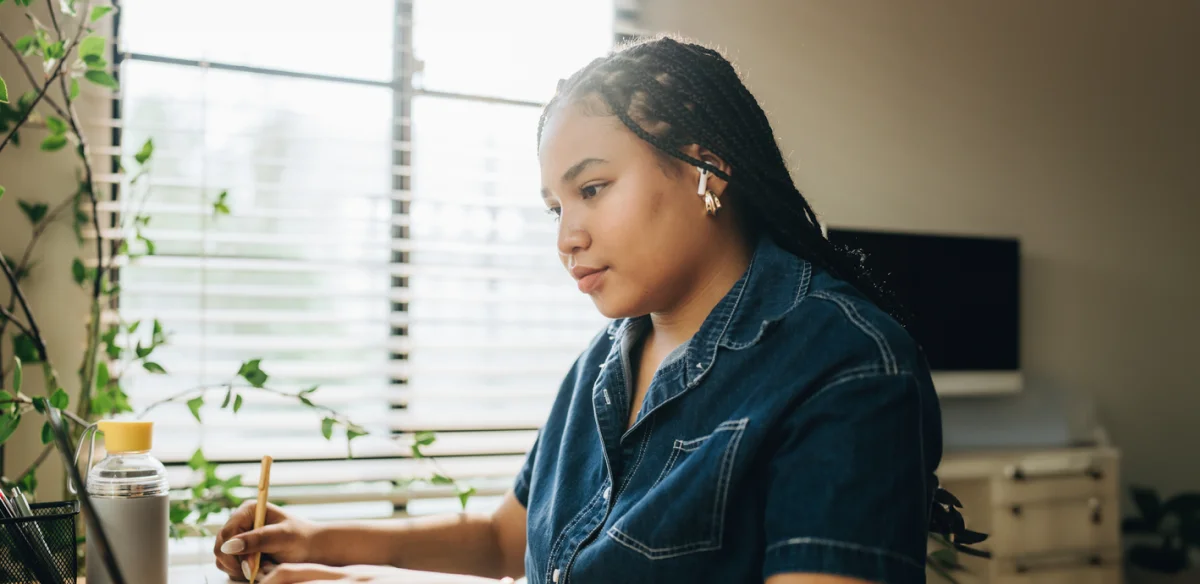 Student taking notes at her desk